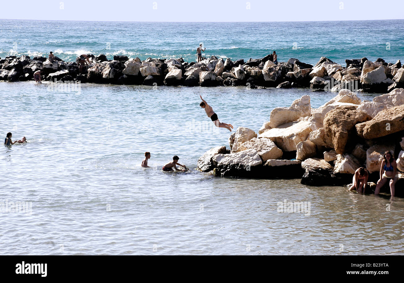 Ein Junge taucht vom Felsen ins Meer bei Trapani, Westsizilien. Stockfoto