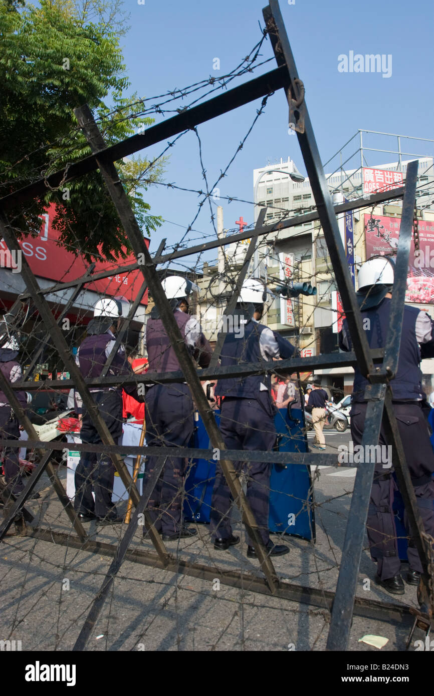 Bereitschaftspolizei gesehen durch eine Stacheldraht-Riot-Barriere, Changhua Taiwan ROC Stockfoto