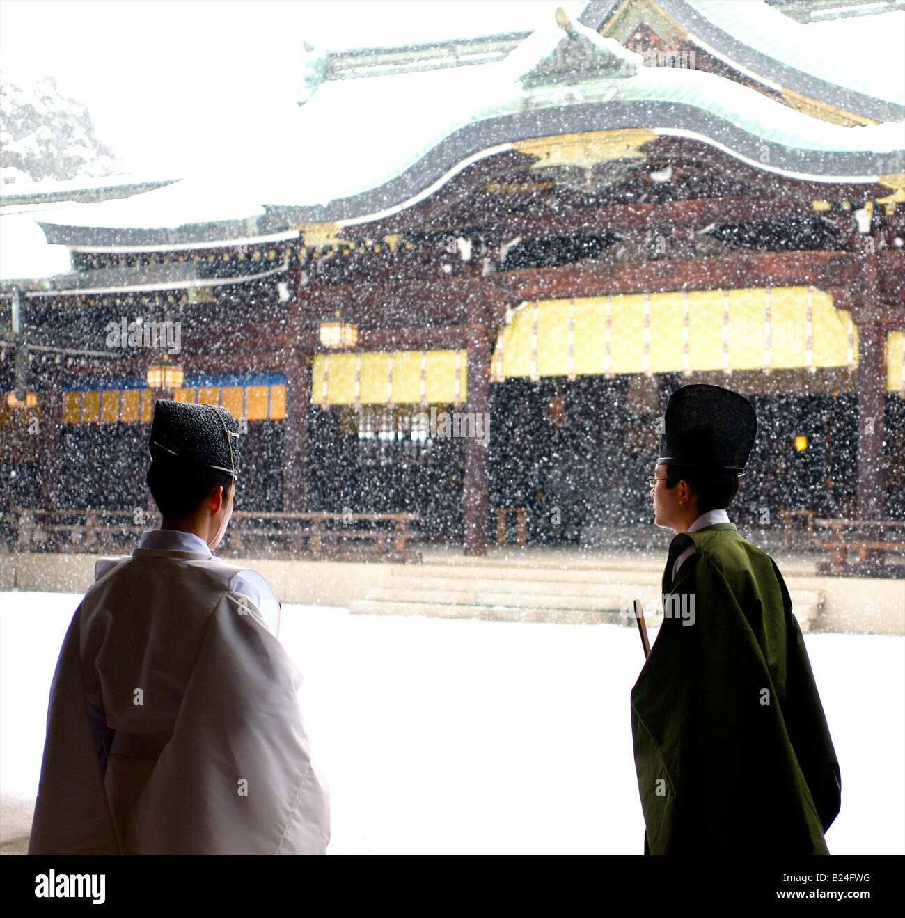 Schneefall hinter zwei Shinto-Priester im Tempel Meiji Jingu - Tokio, Japan Stockfoto