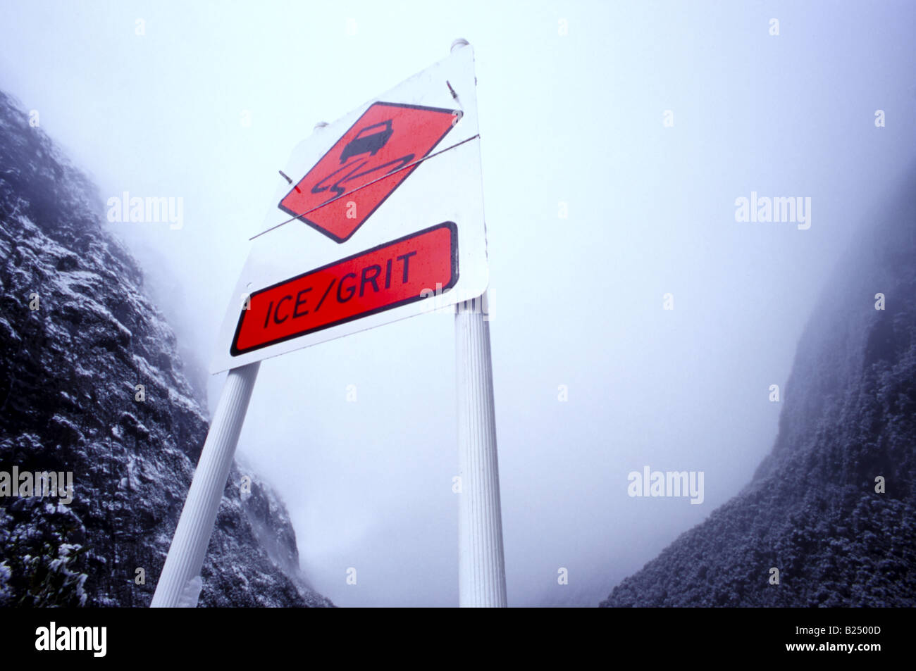 "Beware of Ice" Roadsignwith Hintergrund der Schnee bedeckt Berge entlang der malerischen Milford Road (State Highway 94), Fiordland, NZ Stockfoto