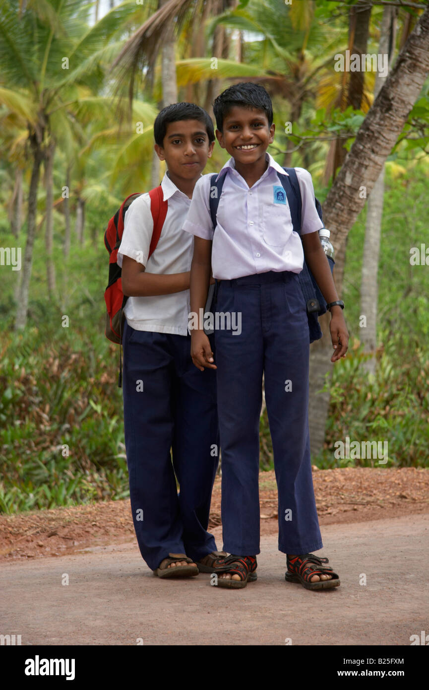 Jungen und seiner Mutter Fuß nach Hause von der Schule in Costa Malabari in der Nähe von Kannur Cannanore North Kerala Indien Stockfoto
