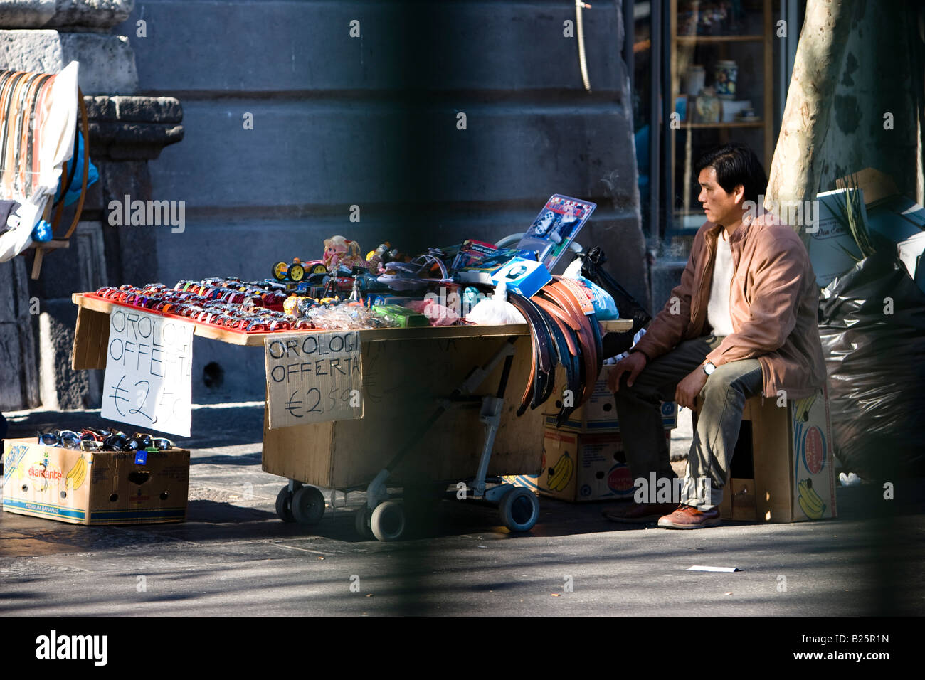 Asiatischer Mann verkauft Schwarzmarkt waren auf Straße in Catania, Sizilien, Italien Stockfoto