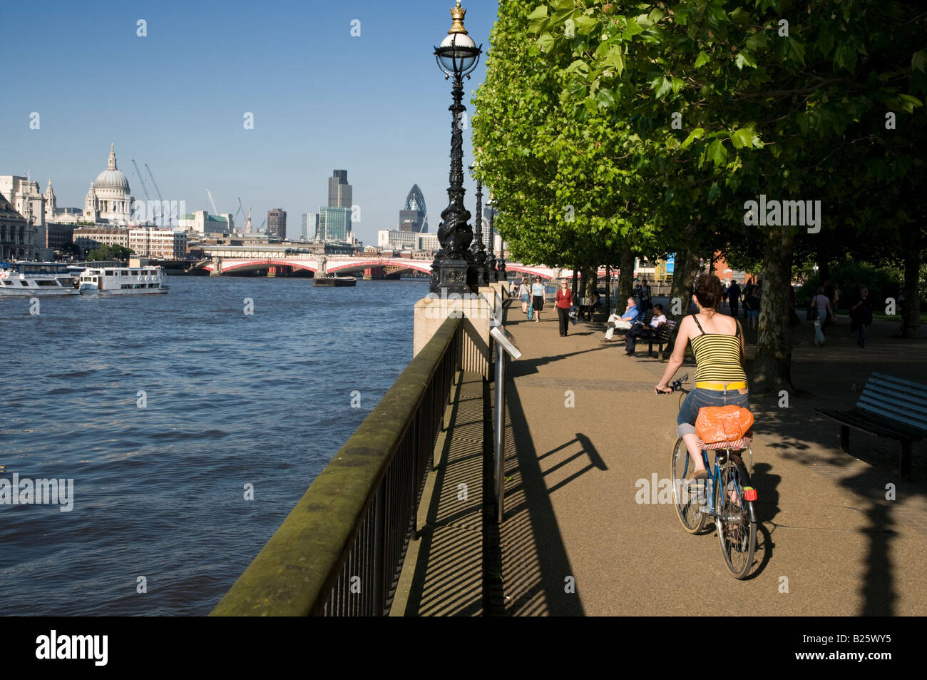 Frau Radfahren am Ufer des Flusses Themse London England UK Stockfoto