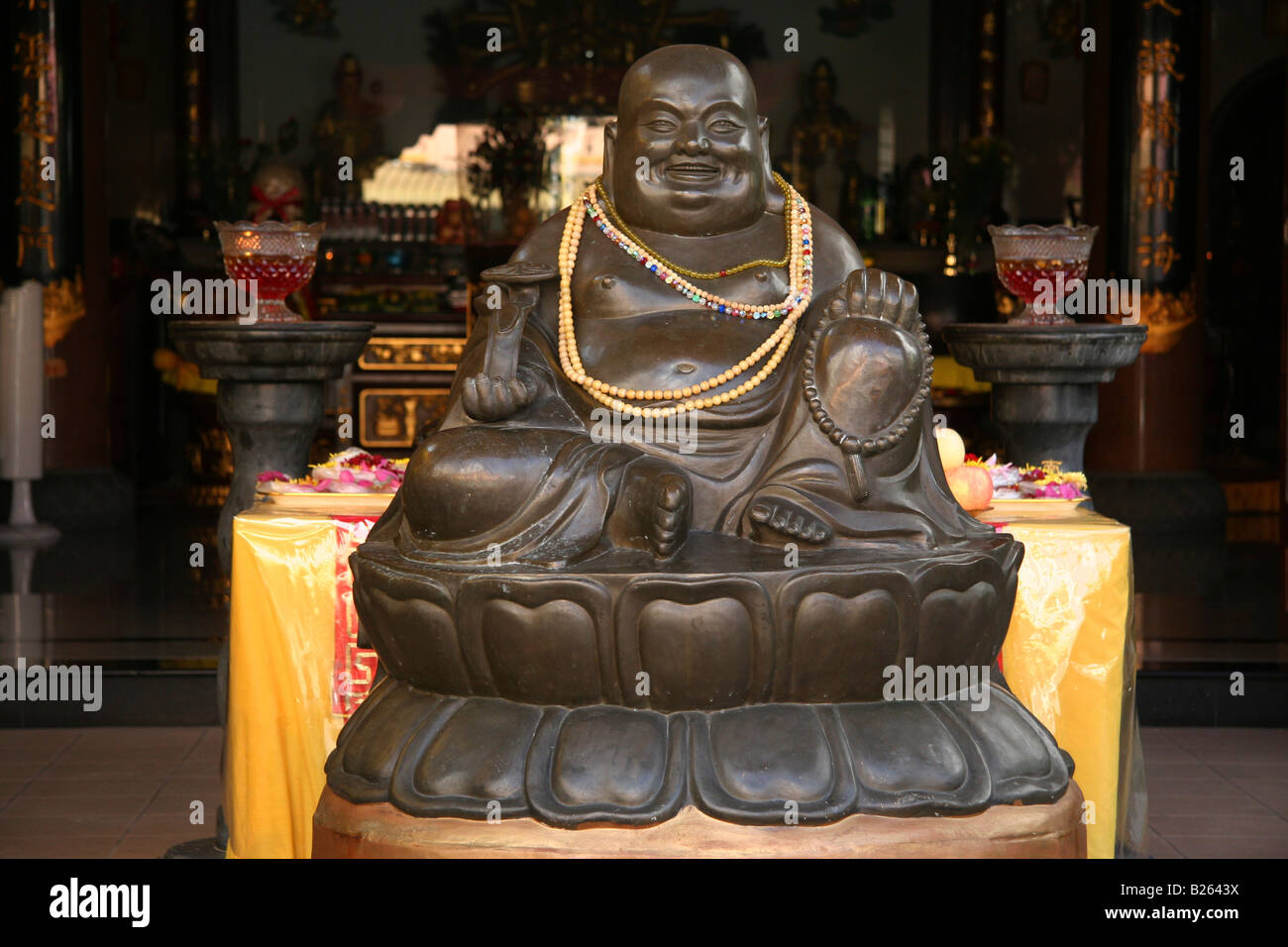 Ein lachender Buddha-Statue am Eingang zu einem buddhistischen Tempel in Singapurs Chinatown. Stockfoto