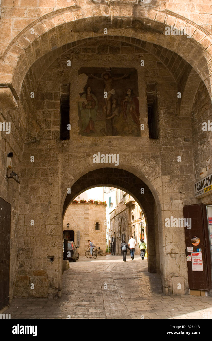 Ein Bogen in der Stadtmauer ist mit einem Bild von Jesus Christus in der Stadt Polignano, Italien dekoriert. Stockfoto