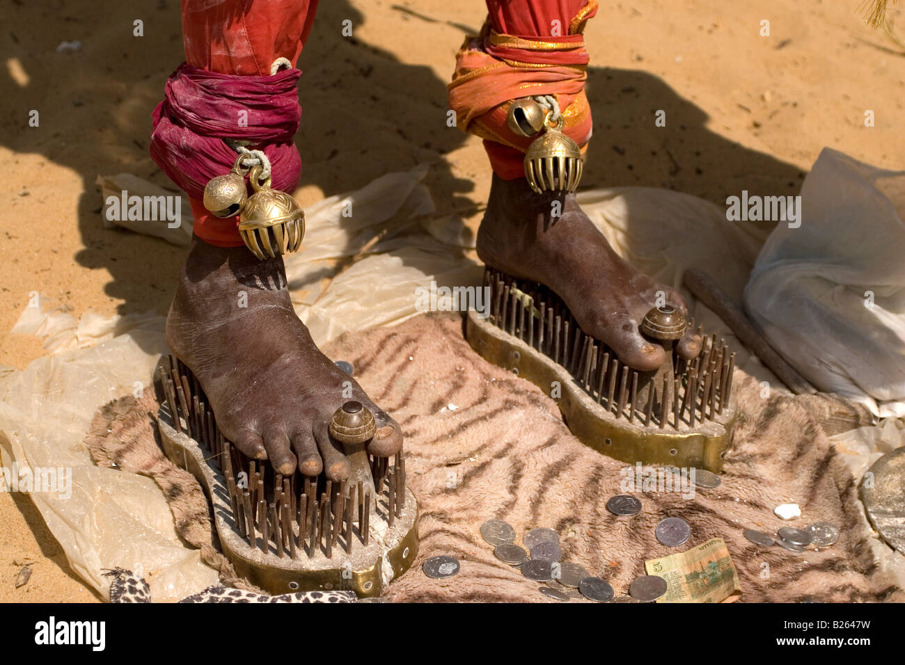 Ein Sadhu steht unter einem Sonnenschirm auf Schuhe von Nägeln bei Talakkad in Karnataka stehend. Stockfoto