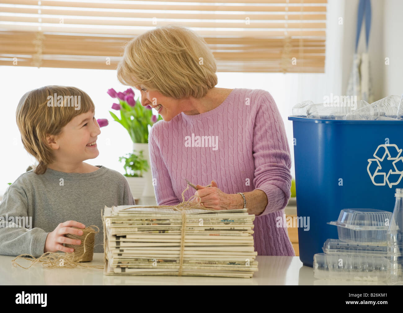 Großmutter und Enkel recycling Zeitungen Stockfoto
