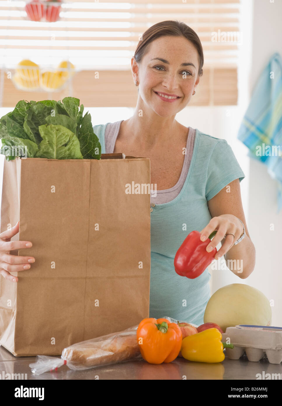 Hispanic schwangere Auspacken Lebensmittel Stockfoto