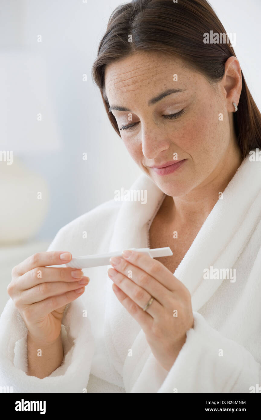 Hispanic Frau betrachten Schwangerschaftstest Stockfoto