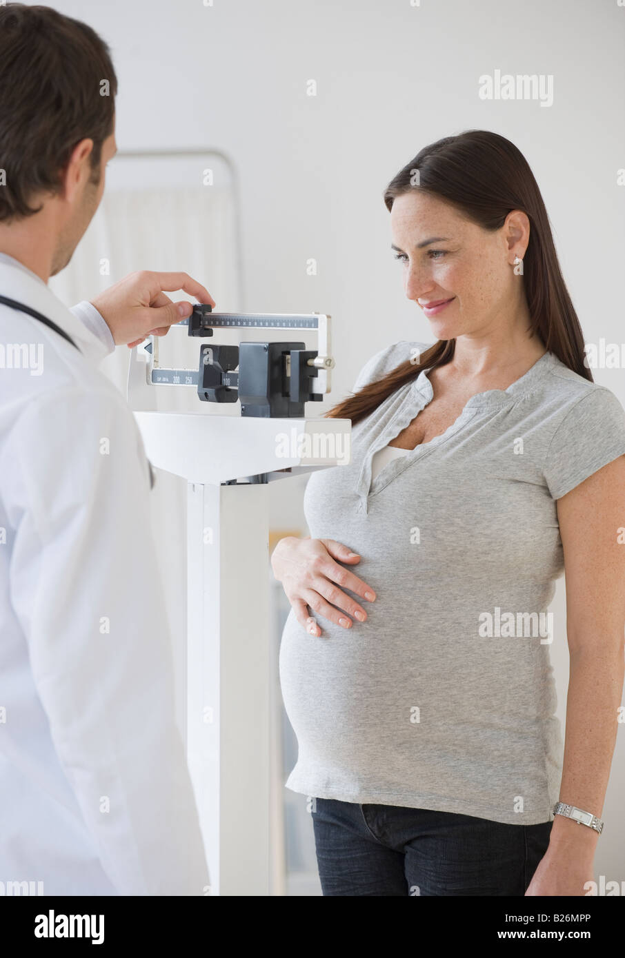 Hispanic schwangere auf Skala in Arztpraxis Stockfoto