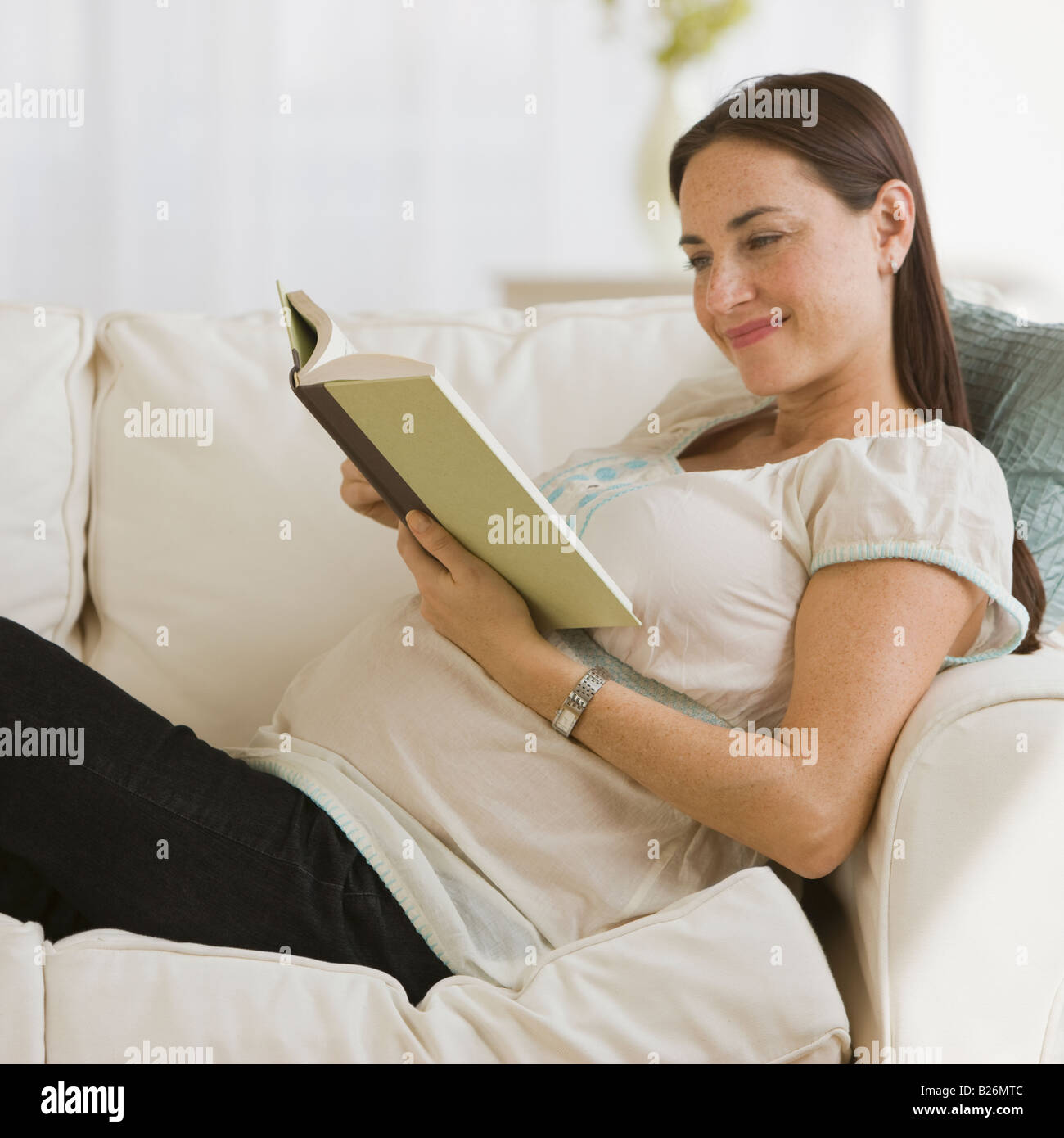 Schwanger Hispanic Frau Lesebuch Stockfoto