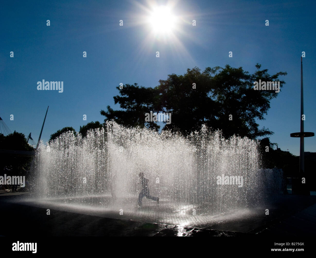 In einem Brunnen Silhouette gegen die Sonne spielendes Kind Stockfoto
