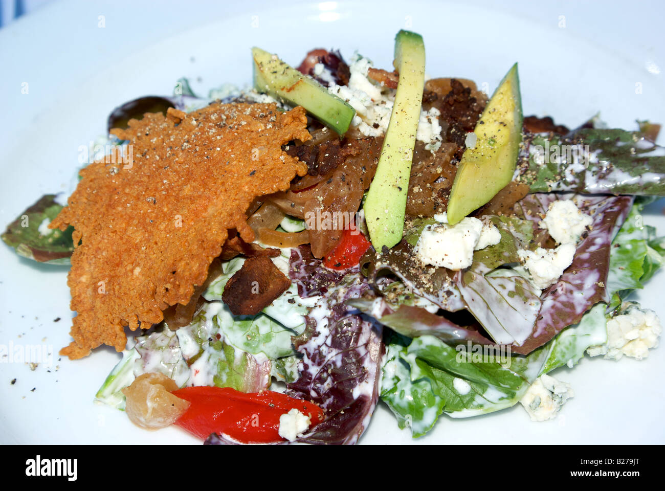 Gemischter Salat mit Käse knusprig karamellisierten Zwiebeln Speck Blauschimmelkäse Tomaten und avocado Stockfoto