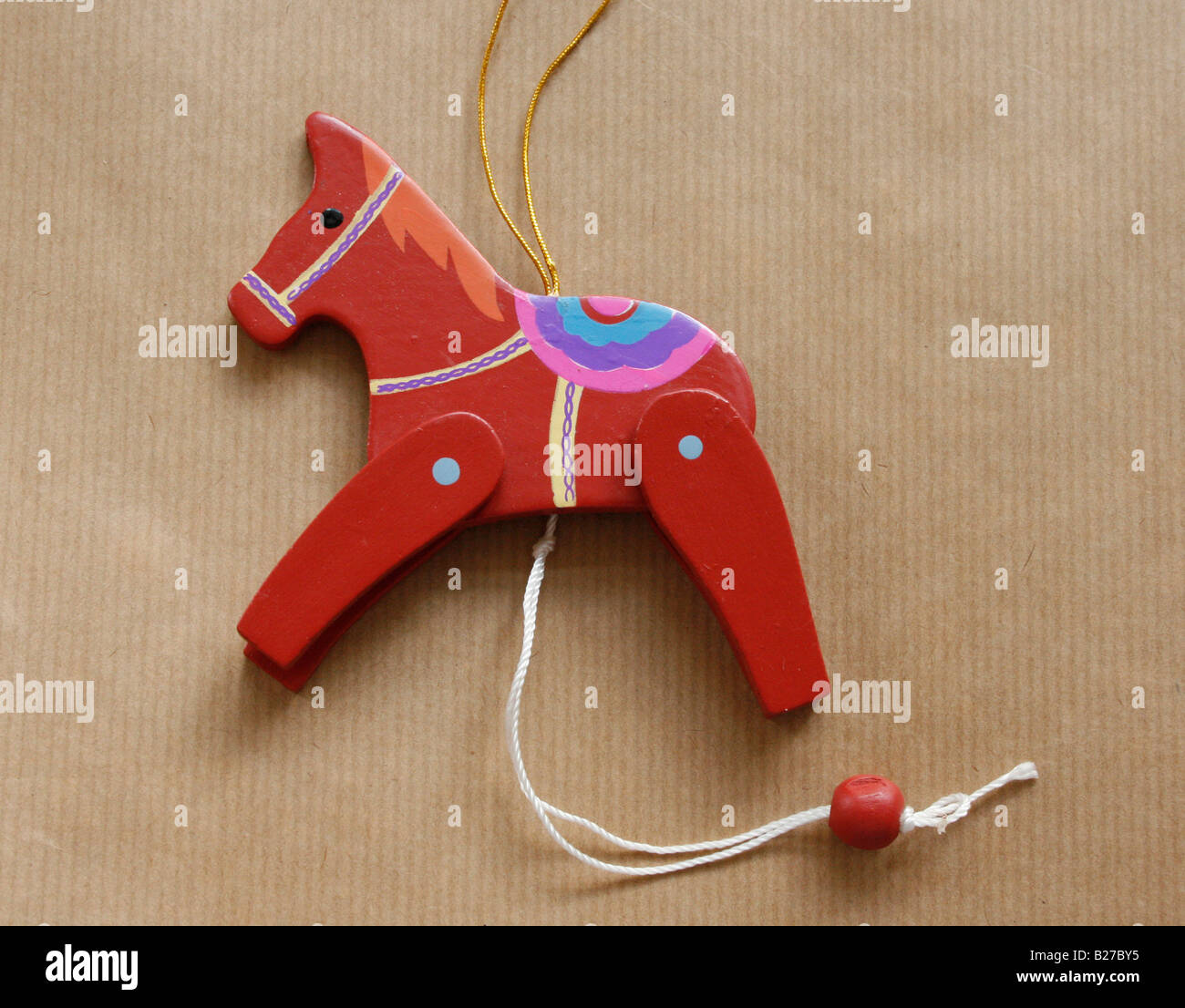 Weihnachten: Eine bemalte Holzspielzeug Pferd auf braunem Papierhintergrund.  (Foto-Extras) Stockfoto