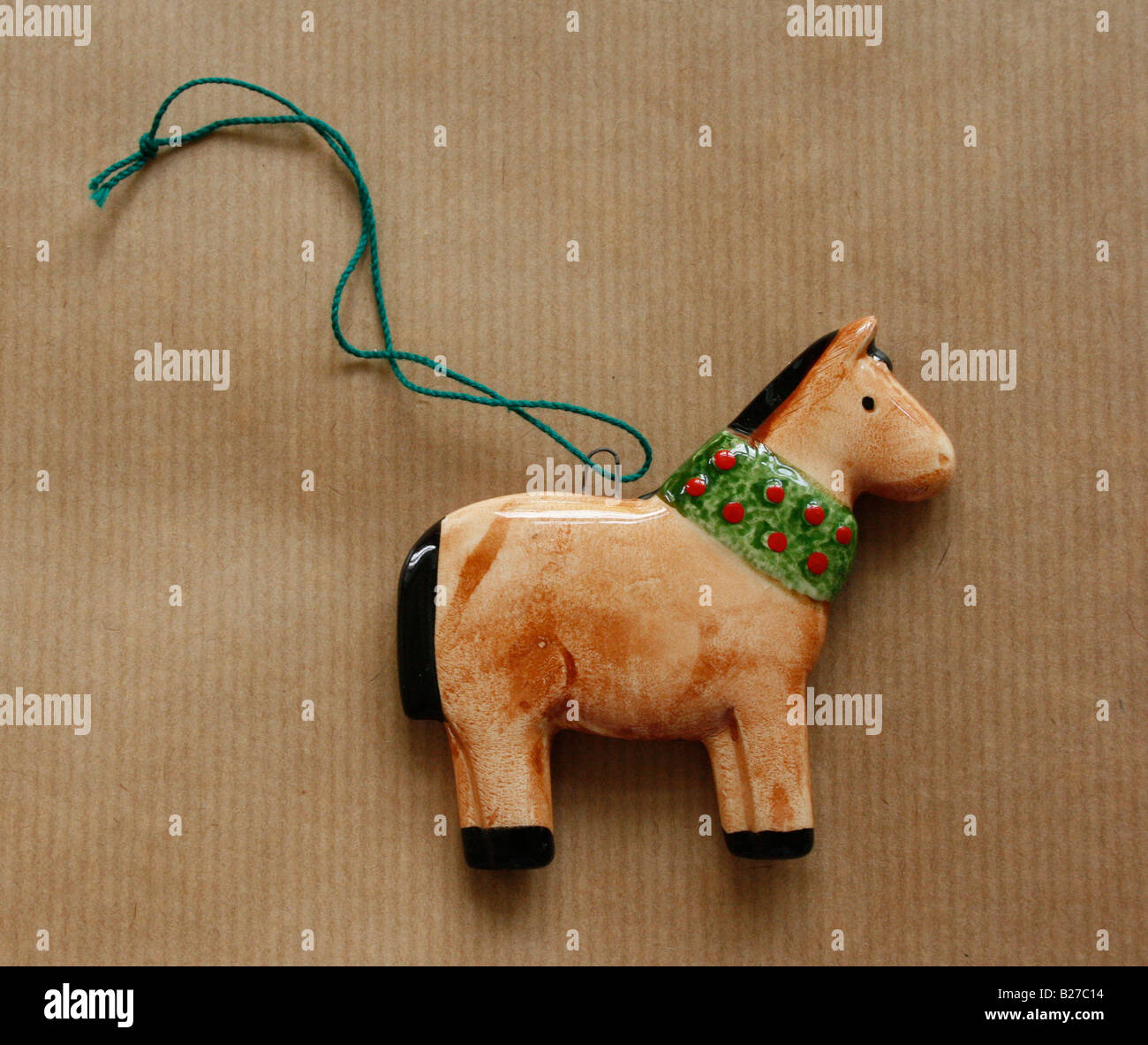 Weihnachten: Eine bemalte Keramik Pferd auf braunem Papierhintergrund.  (Foto-Extras) Stockfoto