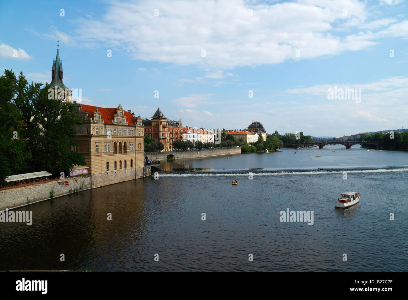 Ein Blick auf die Moldau von der Karlsbrücke in Prag, mit historischen Gebäuden, Boote, blauer Himmel, Wolken und Brücken. Stockfoto
