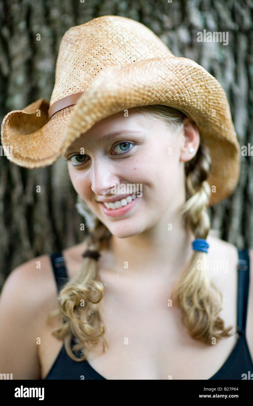 Porträt des jungen College oder einer Universität Alter weibliche Frau im schwarzen Tank-Top mit Stroh Cowboy Hut draußen im freien Lächeln Stockfoto
