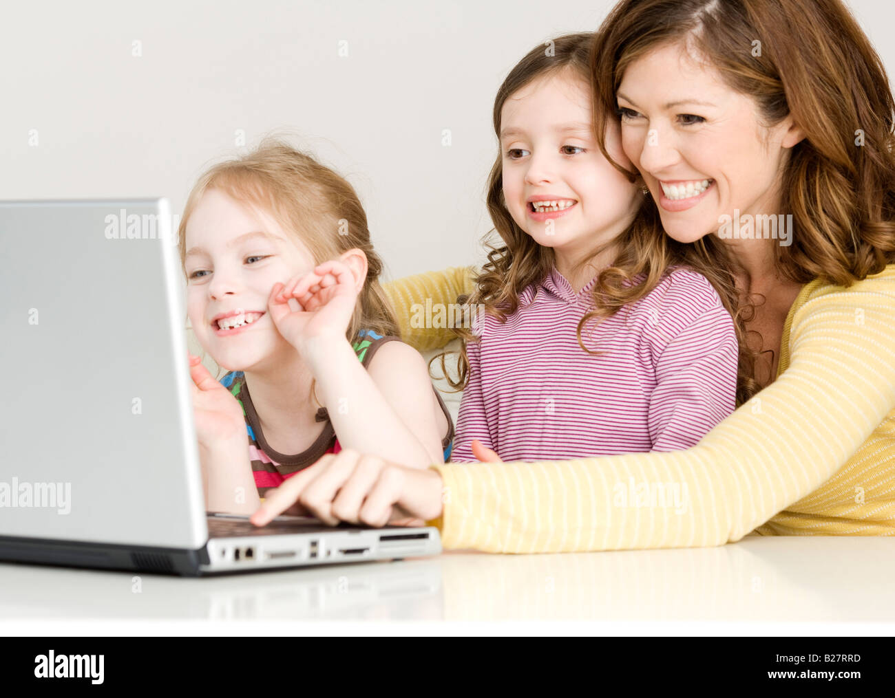 Mutter und Töchter Blick auf laptop Stockfoto
