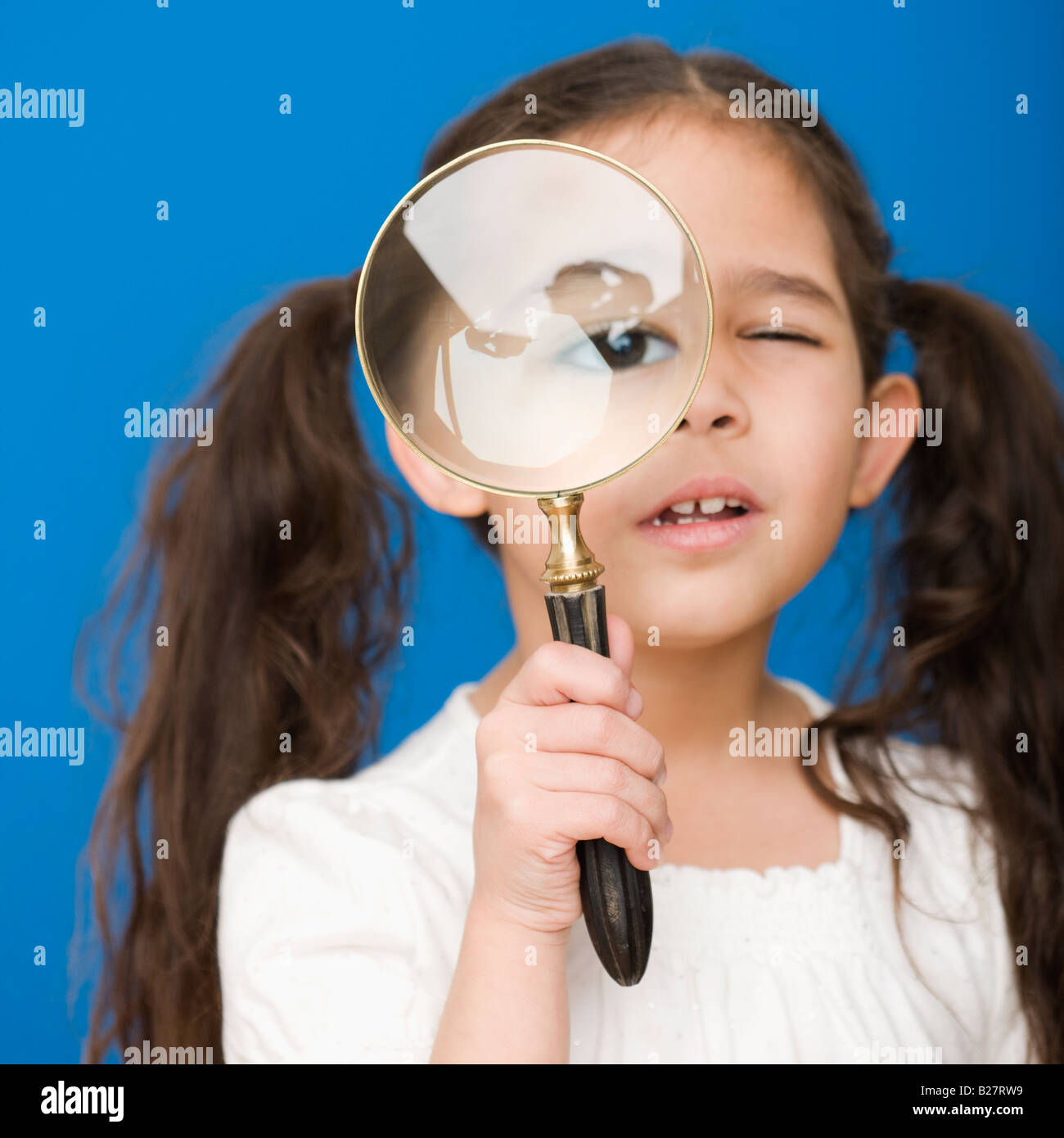 Hispanischen Mädchen Blick durch die Lupe Stockfoto