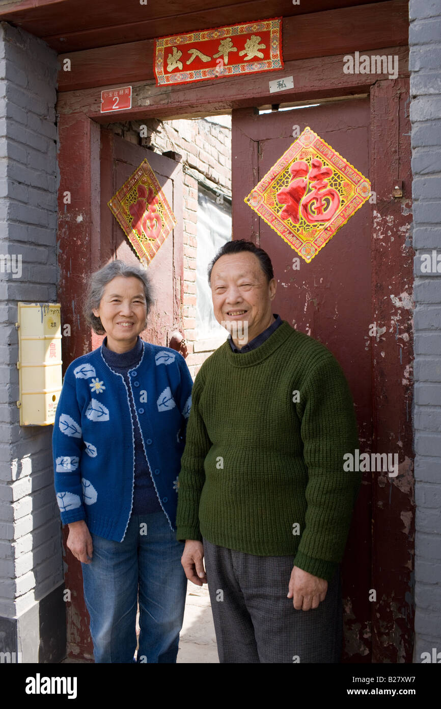 Herr und Frau Wu außerhalb der eigenen Wohnung im Bereich Hutongs Peking China Stockfoto