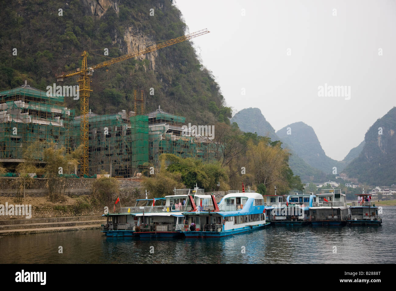 Touristischen Boote vertäut auf dem Li-Fluss bei Yangshuo durch eine Baustelle Hotel China Stockfoto