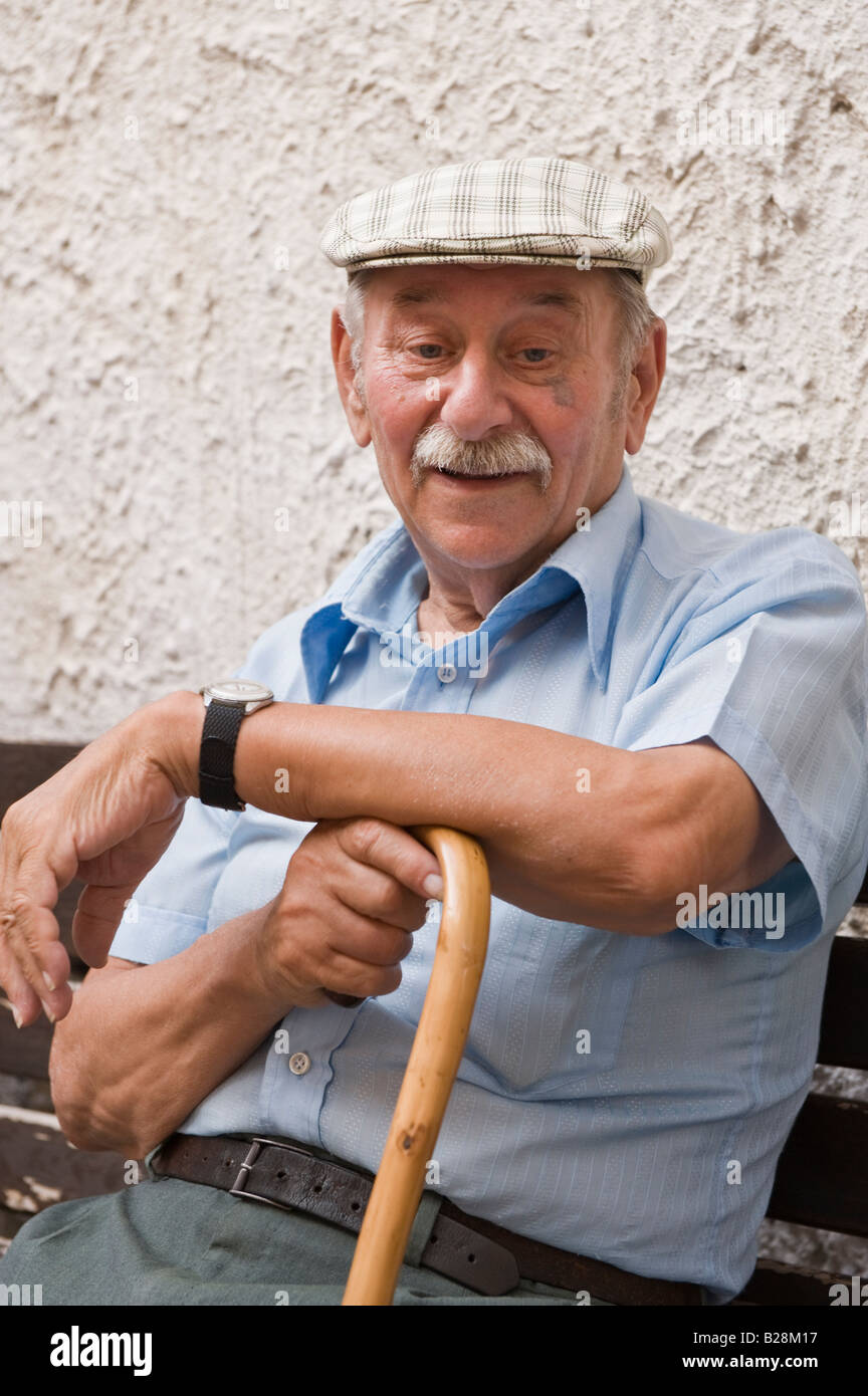 Älterer Herr auf Bank sitzend Stockfoto