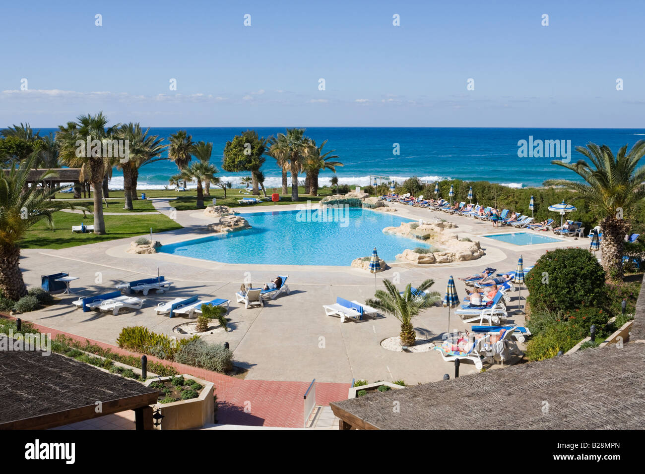 Das Schwimmbad neben dem Mittelmeer im Venus Beach Hotel, Paphos, Zypern Stockfoto