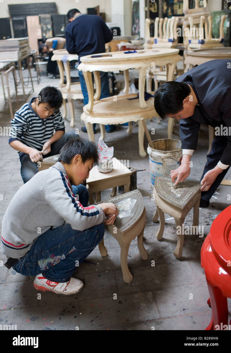Intarsien-Handwerkern bei der Arbeit an Lack Tischen von Souvenir- und Möbel-Fabrik Xian China Stockfoto
