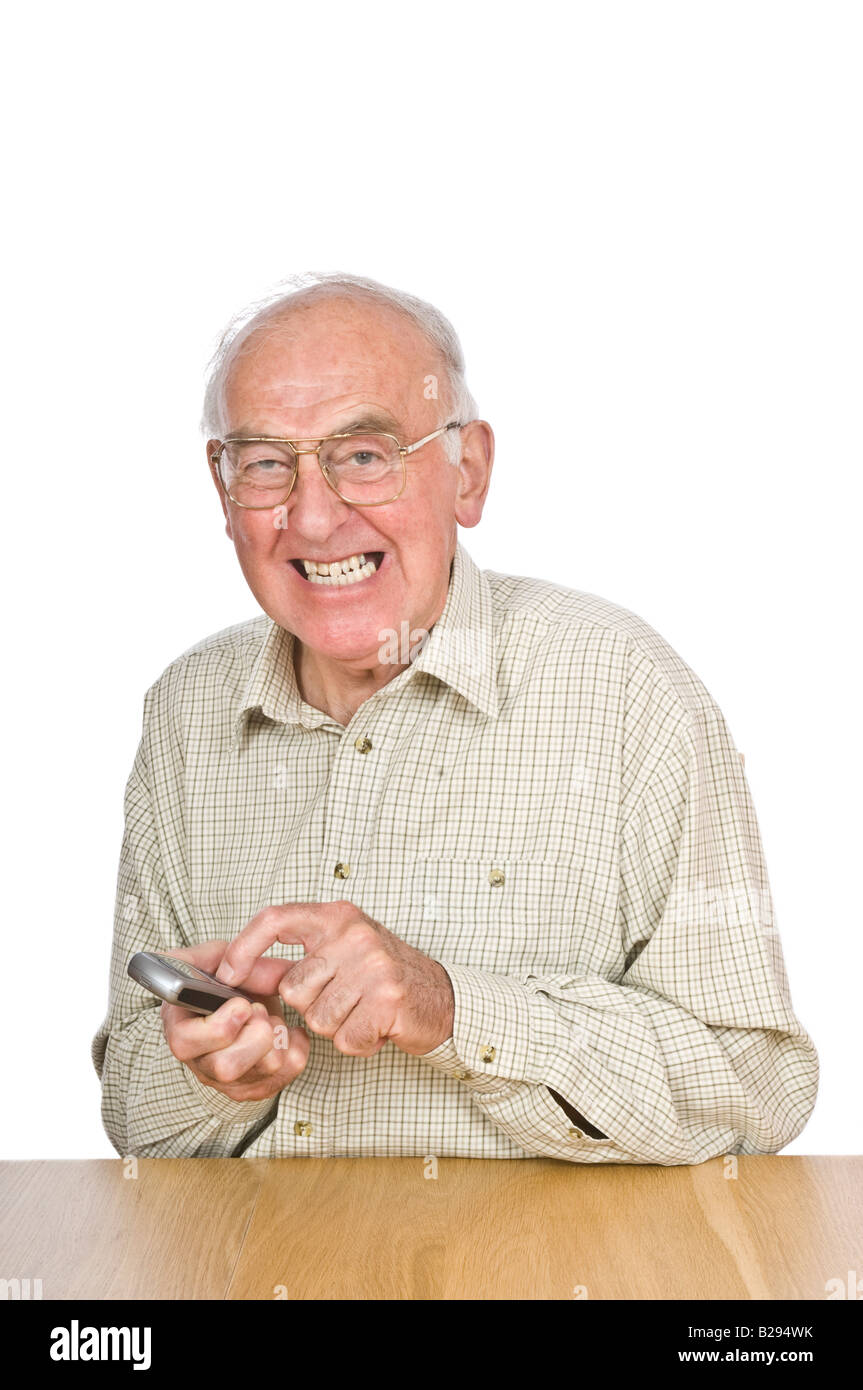 Ein älterer Mann immer frustriert versucht, Text oder das Handy mit den kleinen Knöpfen und Zahlen zu verwenden. Stockfoto