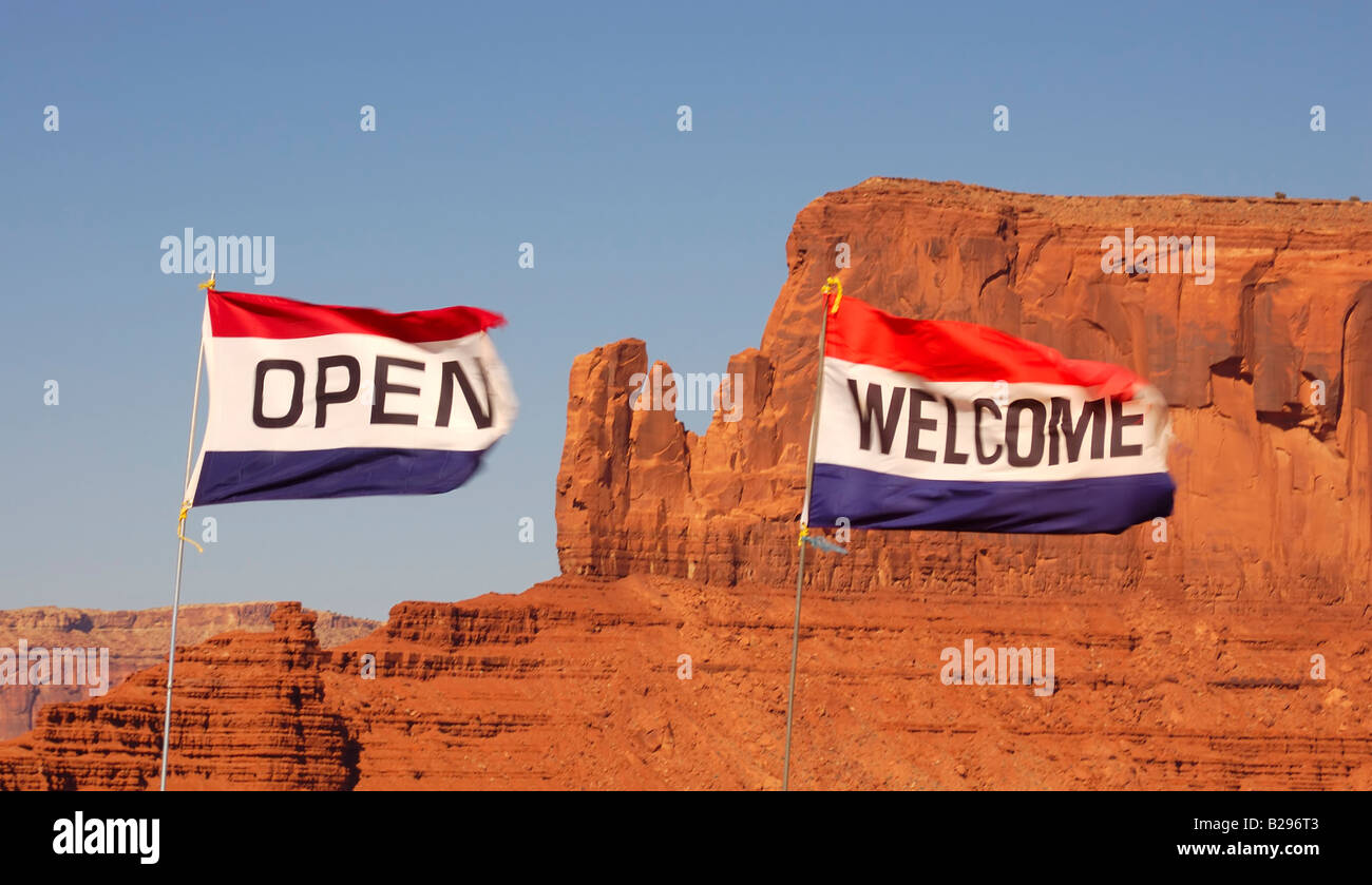 Öffnen und willkommen Flaggen sind von einem starken Wind vor roten flachen Mesa in Monument Valley Navajo Nation Schlagsahne Stockfoto