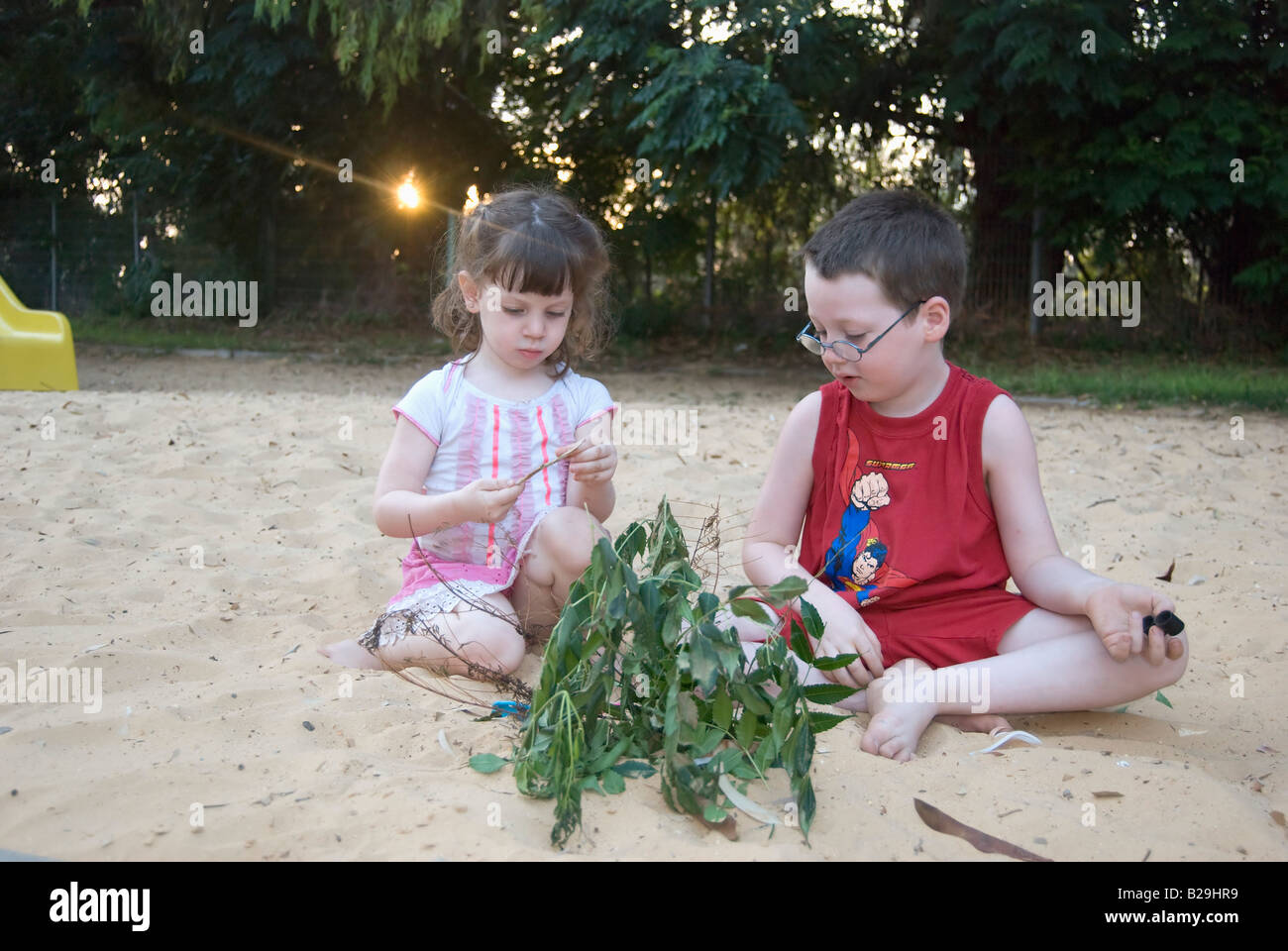 2 Kinder junge im Alter von 5 und Mädchen im Alter von 3 spielen im Sandkasten Model-Release verfügbar Stockfoto