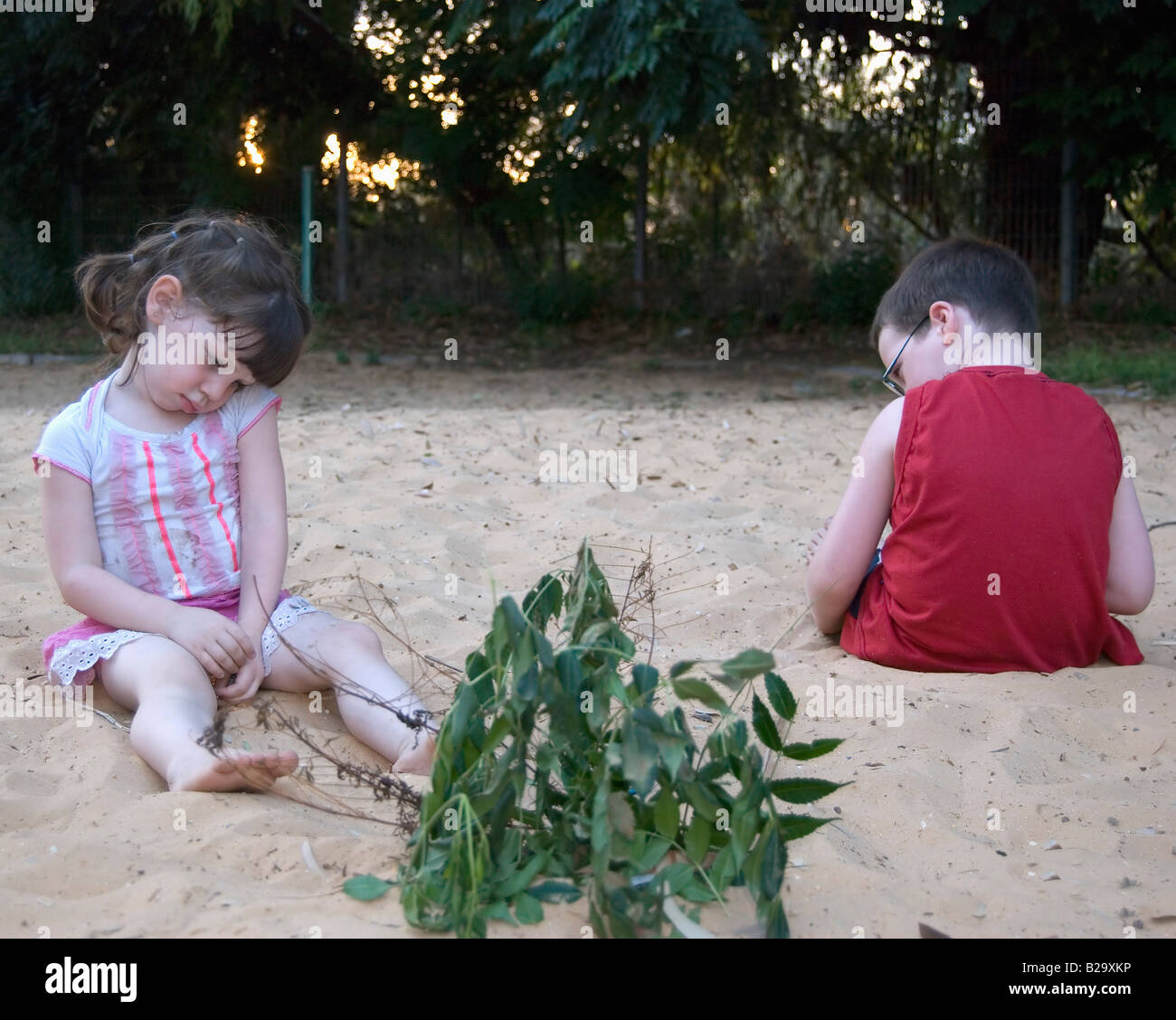 2 Kinder junge im Alter von 5 und Mädchen im Alter von 3 spielen im Sandkasten bei einem Streit Model-Release verfügbar Stockfoto