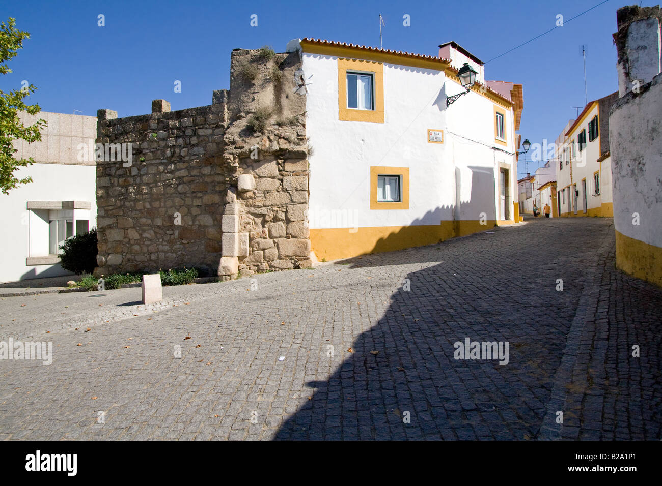 Straße von Crato mit Blick auf die alte Schlossmauer, die von den alten Häusern verwendet. Crato, Portalegre, Alentejo, Portugal. Stockfoto