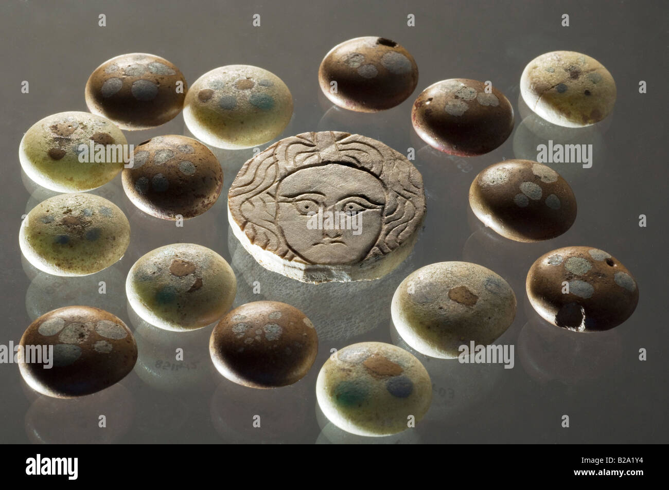 Romano-Britisch decoated Glas Gaming-Zähler rund um das Gesicht der Medusa aus Knochen geschnitzt. 4. Jahrhundert n. Chr. Kent, Großbritannien. Stockfoto