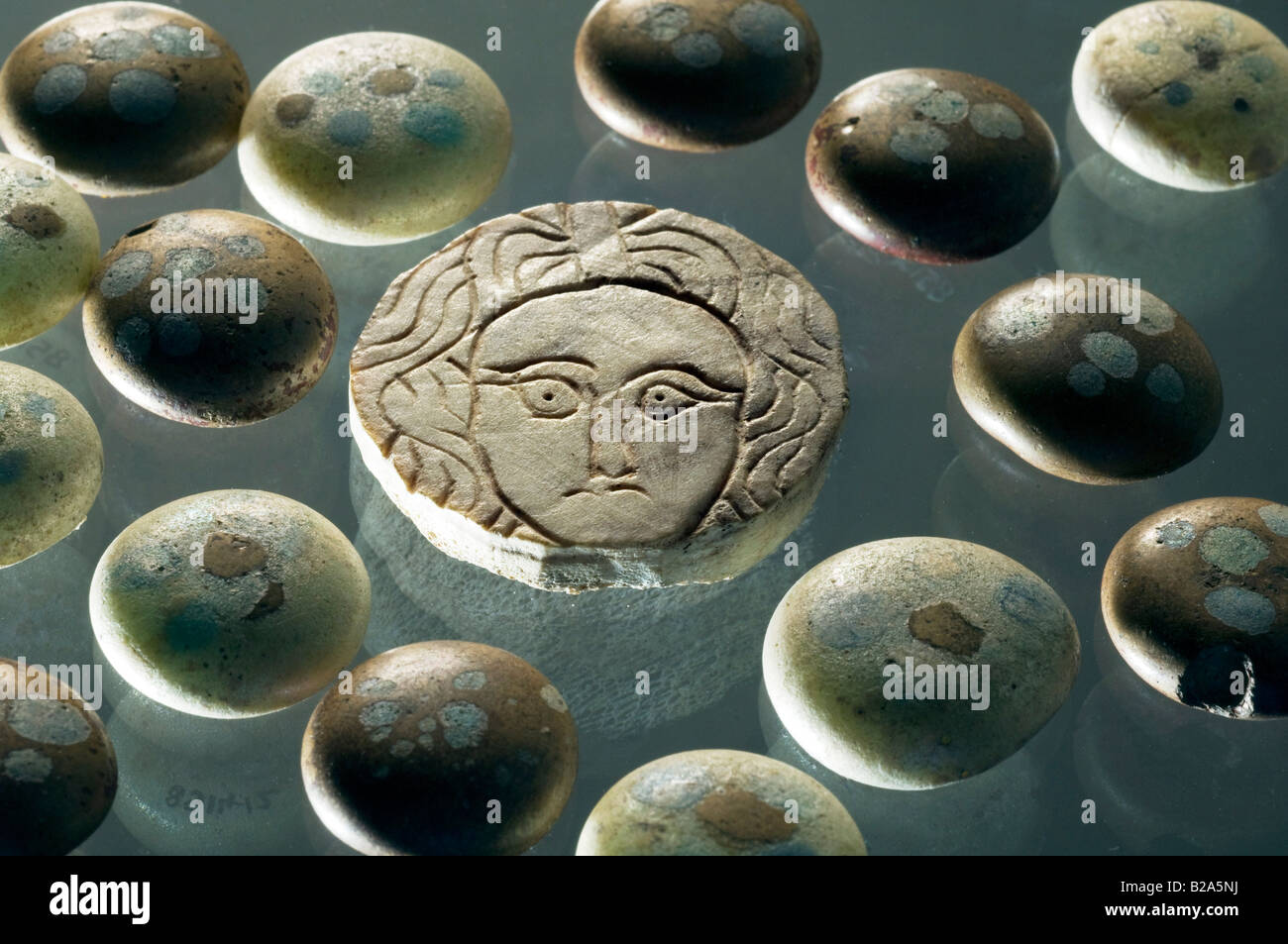 Romano-Britisch decoated Glas Gaming-Zähler rund um das Gesicht der Medusa aus Knochen geschnitzt. 4. Jahrhundert n. Chr. Kent, Großbritannien. Stockfoto