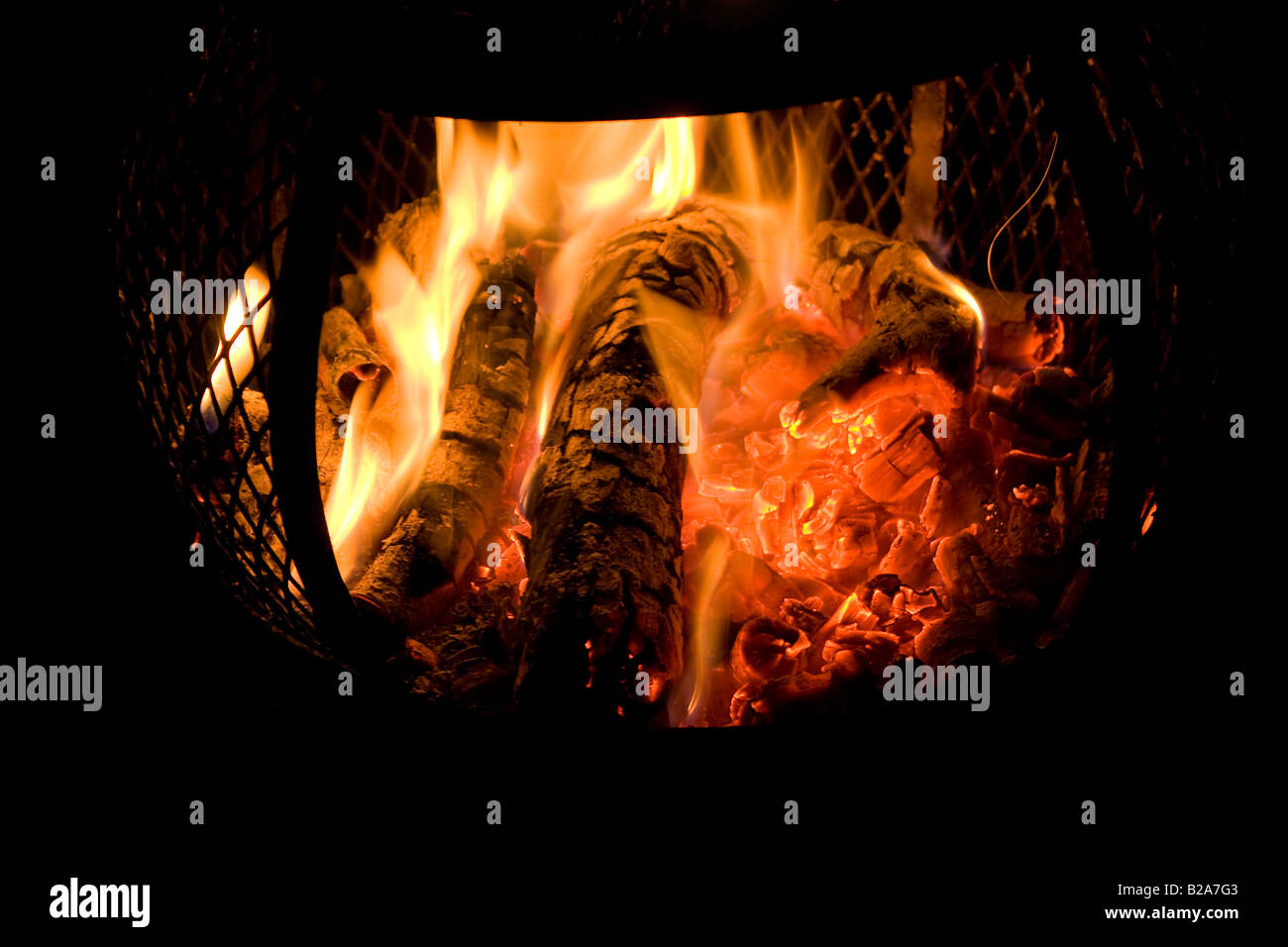 Eine glühende Feuer brennt in einem Hinterhof Chiminea mit rot glühenden Kohlen Stockfoto