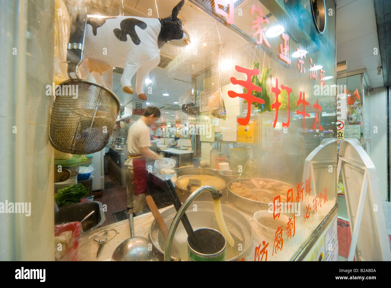 Exterieur der Nudel-Shop-Restaurant auf der Tung Choi Street in Mongkok, Kowloon, Hong Kong, China. Aufblasbare Kuh im Schaufenster. Stockfoto