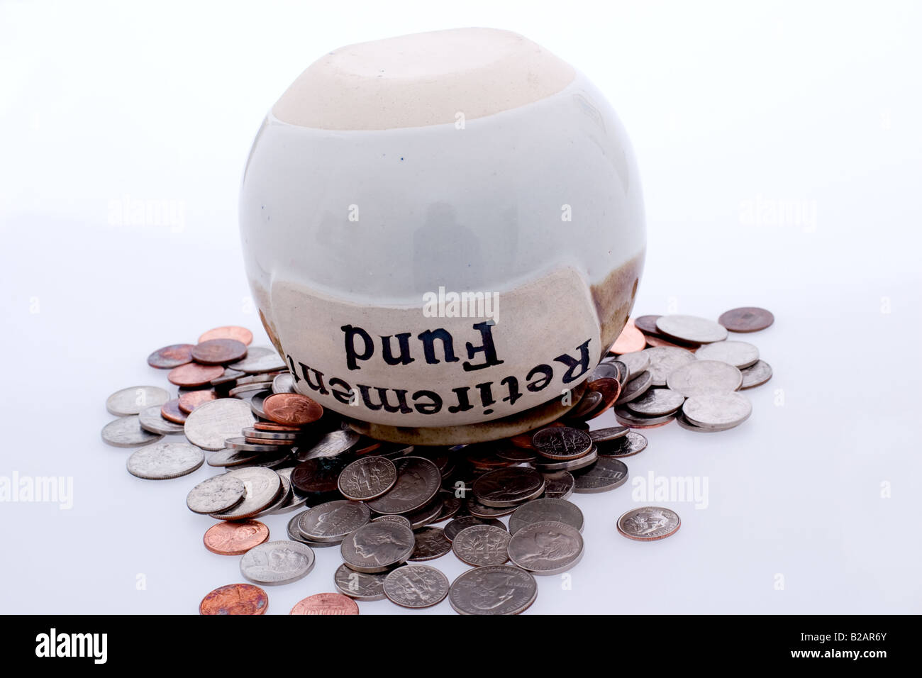 Rente Fonds Glas auf den Kopf gestellt, gefüllt mit mehreren Arten von Münzen Stockfoto