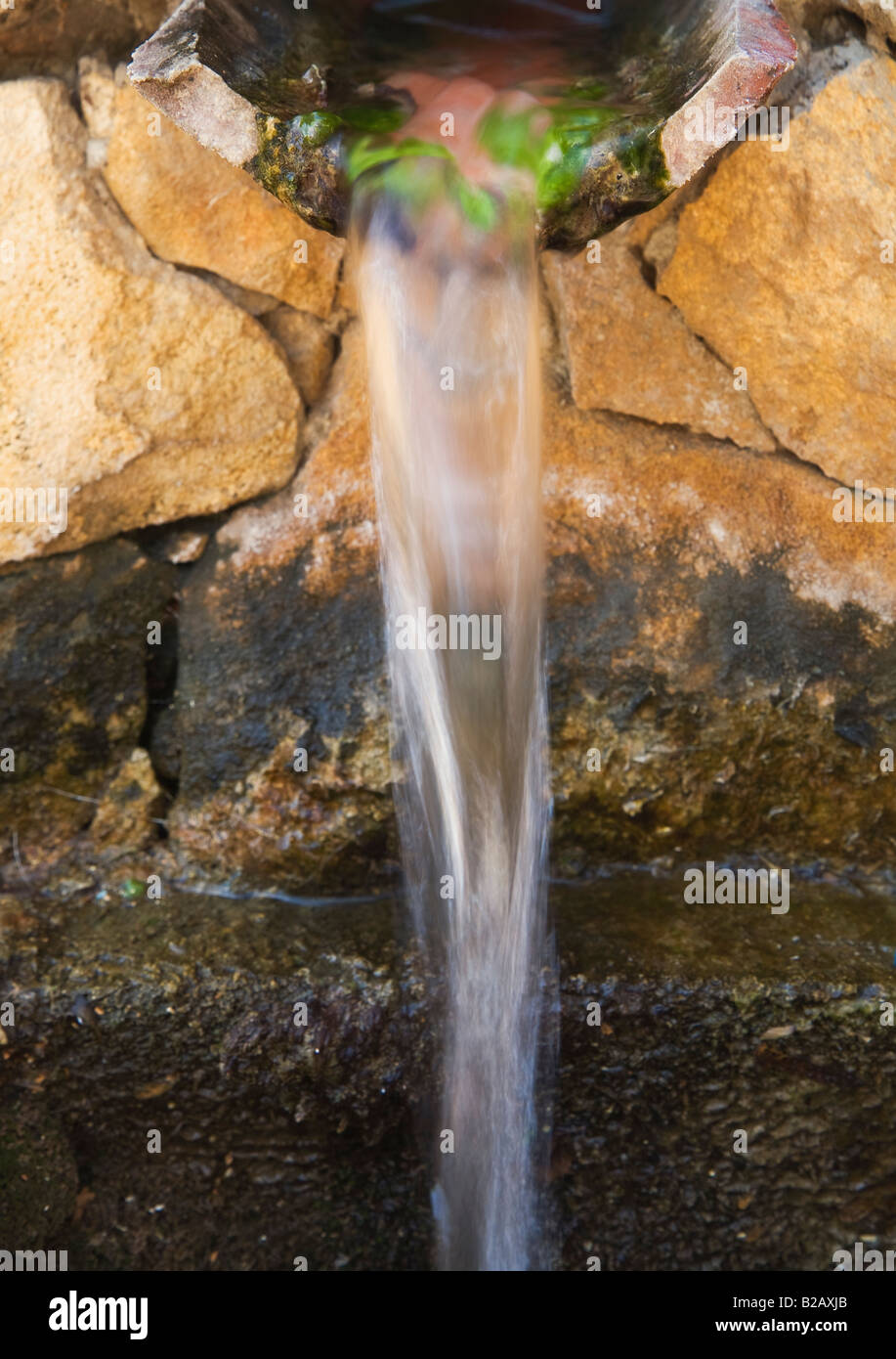 Strom von Wasser aus alten Brunnen gießen Stockfoto