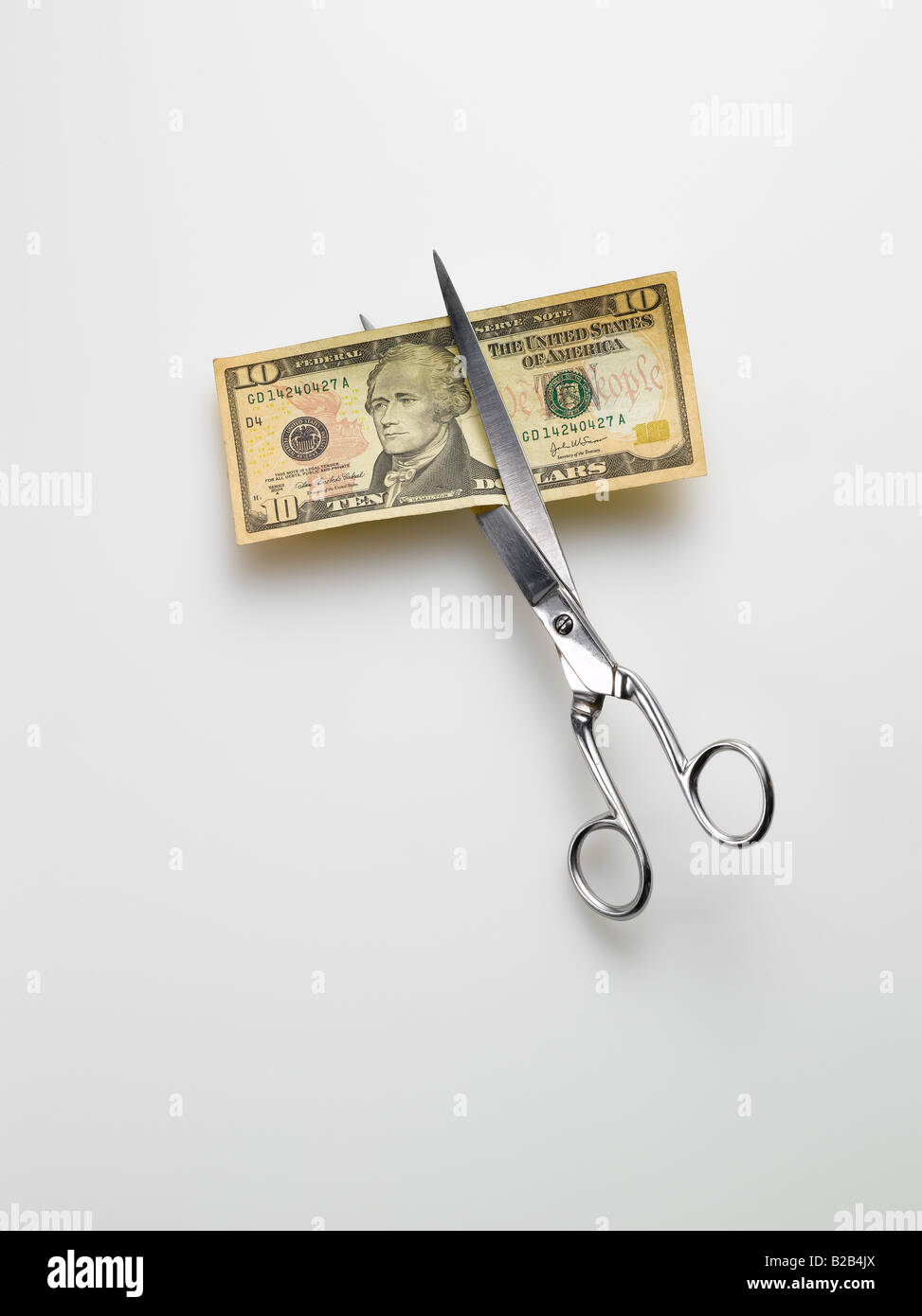 Schere schneiden amerikanischen 10 Dollar bill Geld auf weißem Hintergrund Stockfoto