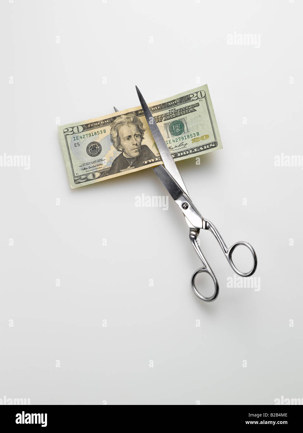 Schere schneiden amerikanischen 20 zwanzig Dollar bill Geld auf weißem Hintergrund Stockfoto