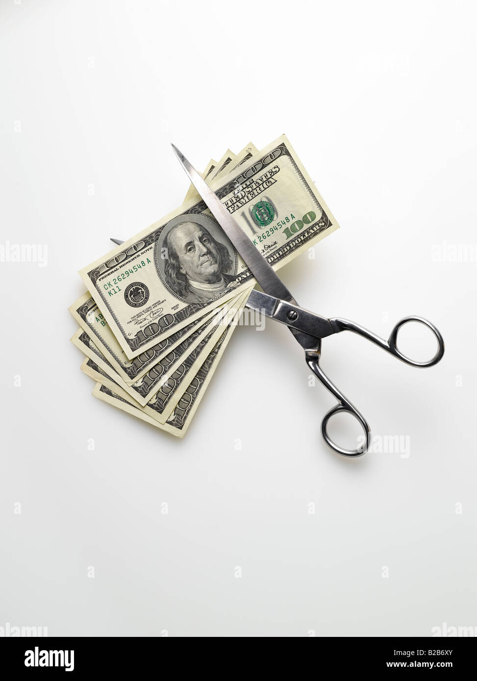 Schere schneiden amerikanische Dollar Rechnungen Geld auf weißem Hintergrund Stockfoto