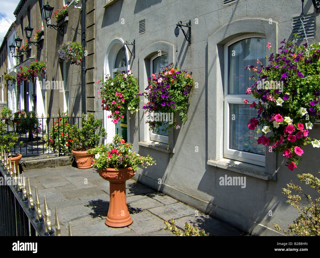 Blumenampeln und Töpfe mit Blumen schmücken das äußere eines Hauses in Skerries County Dublin Irland Stockfoto
