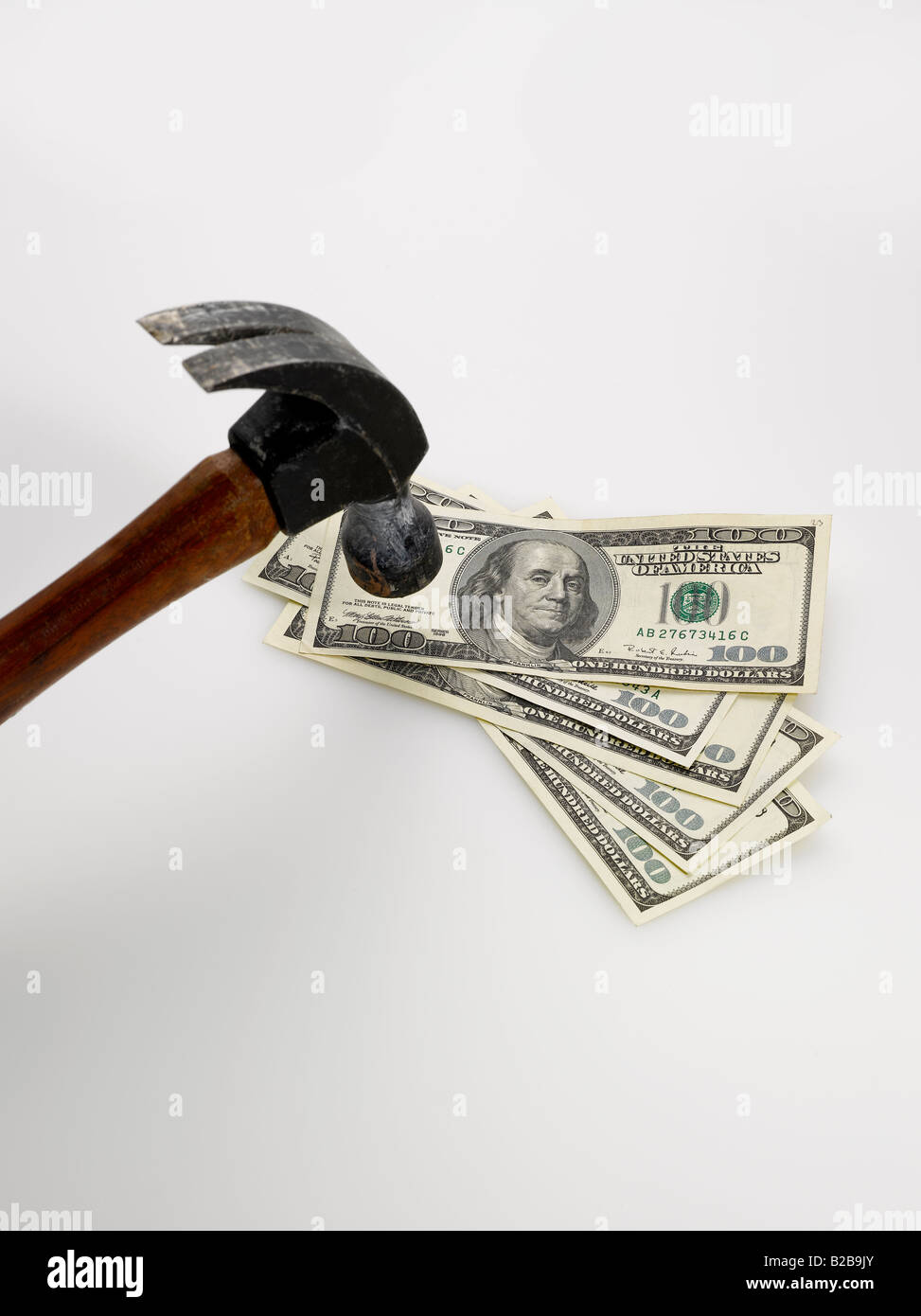 Hammer schlagen amerikanische Dollarscheine auf weißem Hintergrund Stockfoto