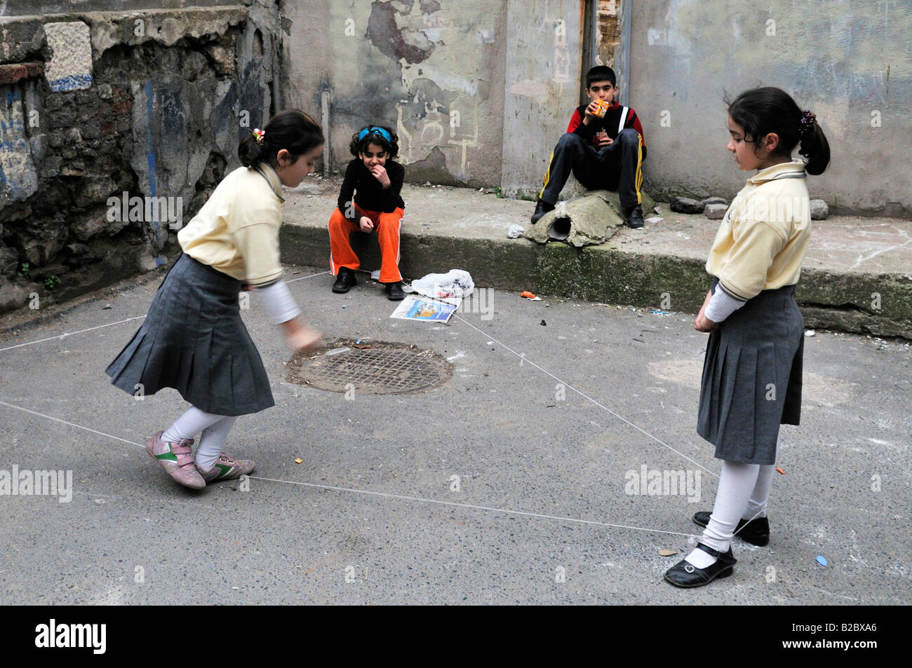 Kinder spielen Gummibänder oder chinesischen Springseil, Stadtteil Cihangir, Istanbul, Türkei Stockfoto
