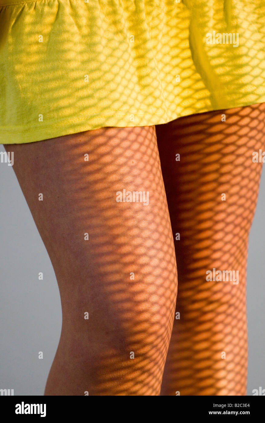 Weibliche Beine in einem Minirock, Lichteffekt Stockfoto