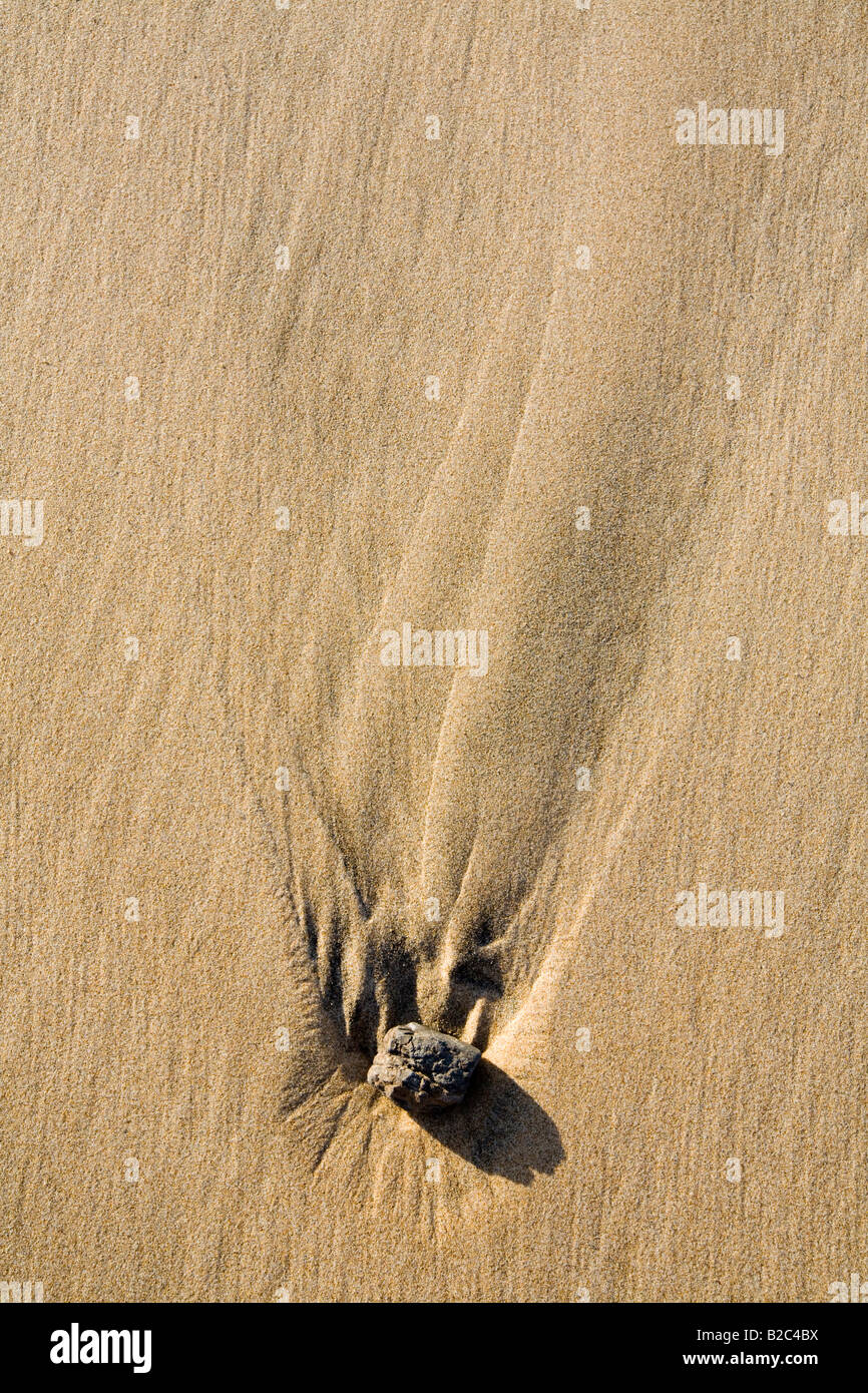 Stein liegt in ein Loch in den Sand, Muster in den Sand in hartes Licht, Strand, Atlantik Stockfoto