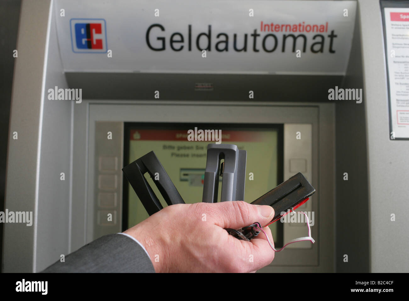 Bankangestellte demonstrieren technische Geräte, die von Kriminellen benutzt, um Zahlen und Pin Codes von Kreditkarten an Geldautomaten auszuspähen Stockfoto