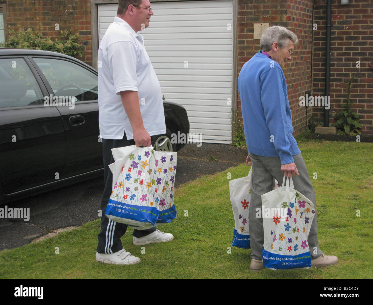 Mann helfen ältere Frau Carry Bag für Leben wiederverwendbare umweltfreundlich einkaufen Tragetaschen Stockfoto