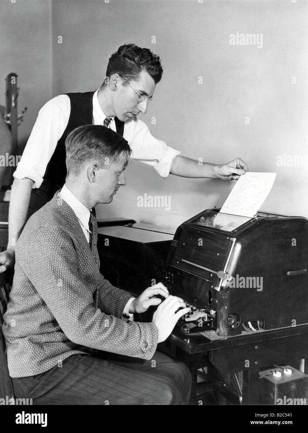 Zwei Männer arbeiten auf einer Schreibmaschine, historische Bild von etwa 1940 Stockfoto